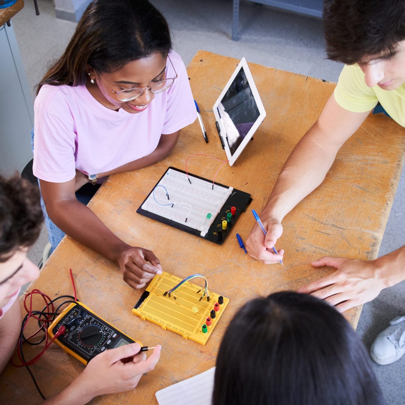 Top view of a group of technical college students doing a team technology project. . High quality photo