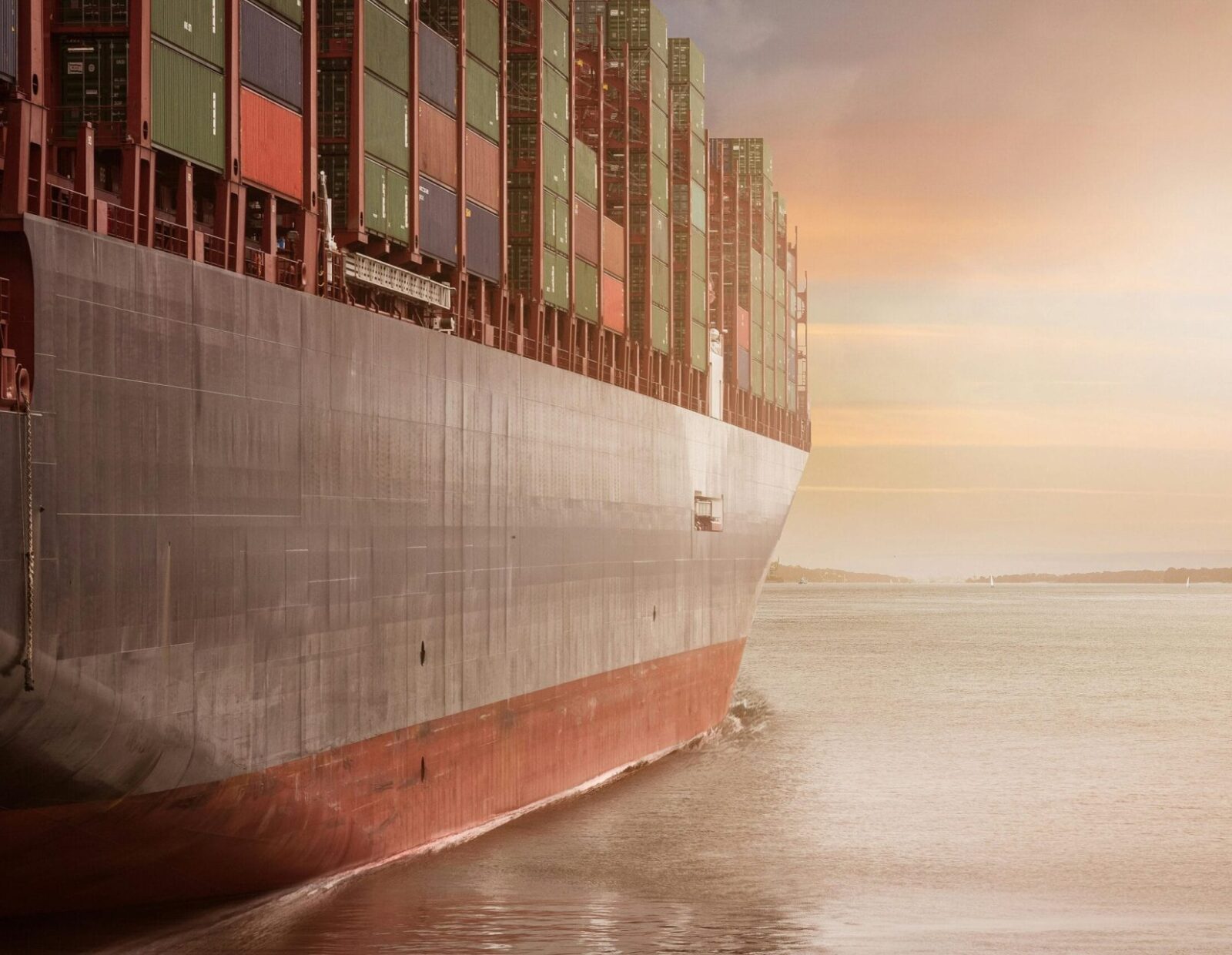 Cargo ship filled with shipping containers sailing in ocean.